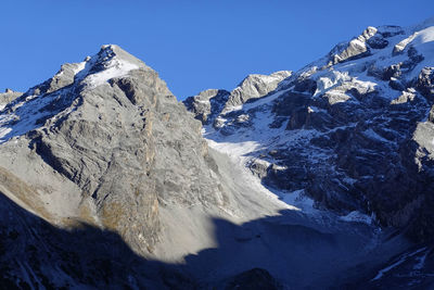 Scenic view of snowcapped mountains against clear blue sky