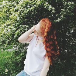 Midsection of woman standing by tree