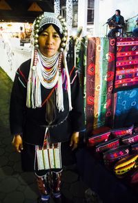 Portrait of woman in traditional clothing standing at market stall