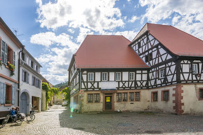 Houses by street in town against sky