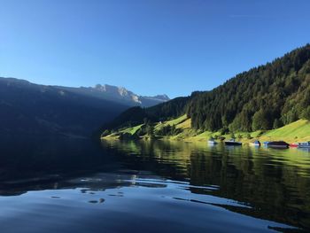 Scenic view of lake and mountains against clear sky