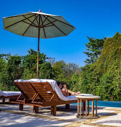 Boy relaxing on lounge chair at poolside