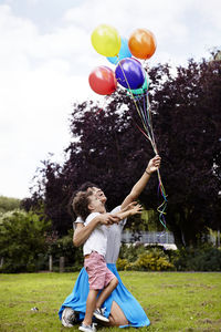 Mother with son holding bunch of balloons