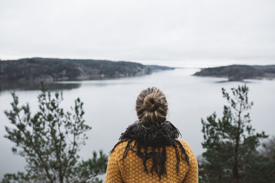 Rear view of woman looking at sea against sky