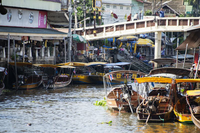 Boats moored in canal by buildings in city