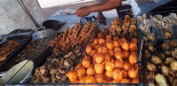 Cropped image of person preparing food at market stall