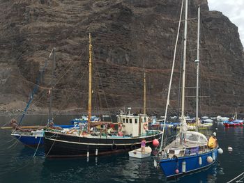 Boats moored at harbor against sky