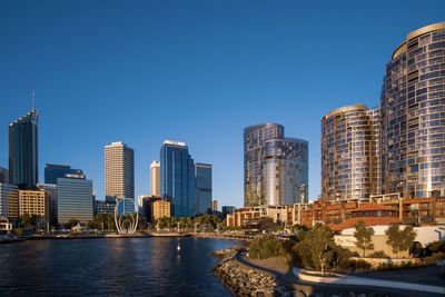 Modern buildings in city against clear blue sky