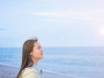 Take a shot at the head of an asian woman walking by the sea. along the beach looking the sky free 