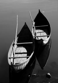 Reflection of man on boat moored in sea against sky