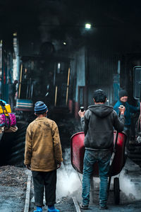 Rear view of people walking on street in city