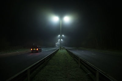 Road in illuminated street at night