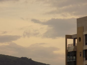 Silhouette buildings against cloudy sky