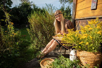 Portrait of young man sitting amidst plants