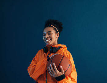 Young man standing against black background