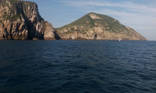 Scenic view of sea and mountains against sky