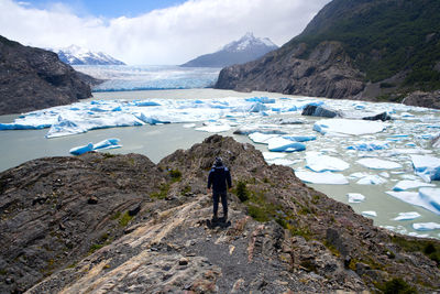 Rear view of man on snowcapped mountains against sky