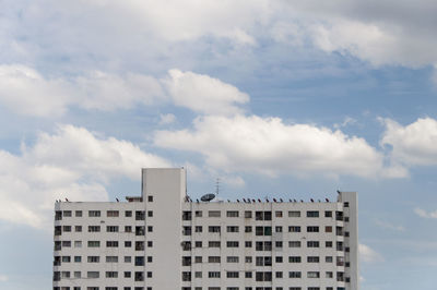 Low angle view of residential building against cloudy sky