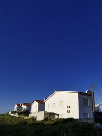 Low angle view of buildings against clear blue sky