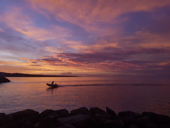 Scenic view of sea against cloudy sky during sunset