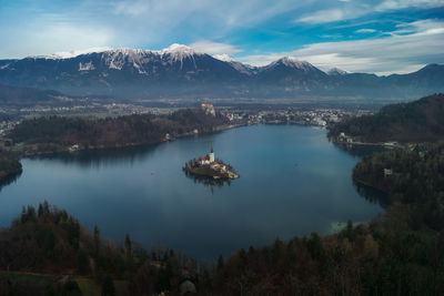 Scenic view of lake by mountains against sky