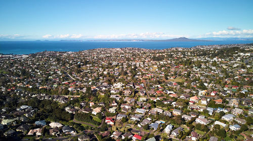 High angle view of townscape by sea against sky