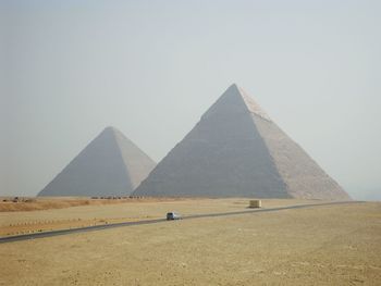Great pyramid of giza on field against sky