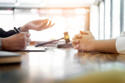 Cropped hands of business people discussing on table