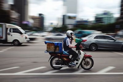 Man carrying container on motorcycle