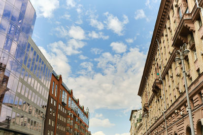 Low angle view of residential modern buildinds, windows and drainpipe. blue sky with clouds.