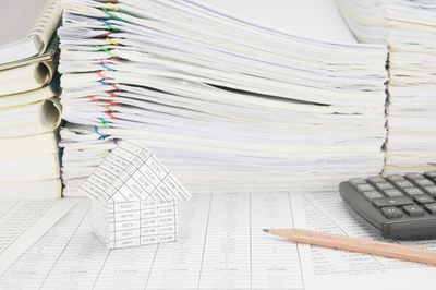 Close-up of model house and calculator on financial documents