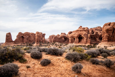 Rock formations on landscape against cloudy sky