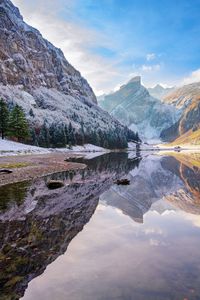 Scenic view of lake and mountains against sky during winter