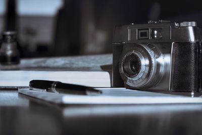 Close-up of camera on table in black and white