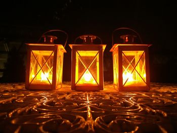 Close-up of illuminated lanterns on table in darkroom