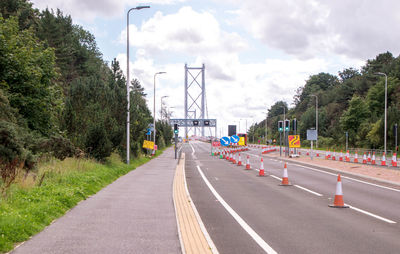 Vehicles on road along trees and plants in city