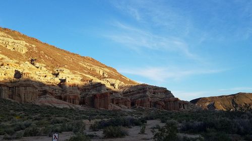 Rock formations on landscape against blue sky