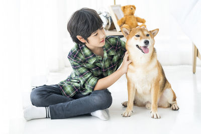 Full length of woman sitting with dog