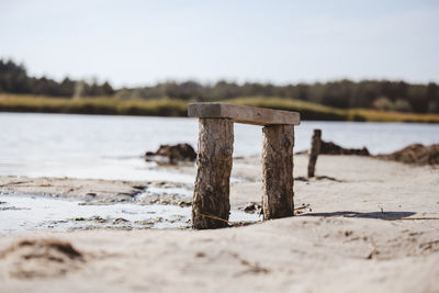 Empty wooden bench by the lake on an autumn day