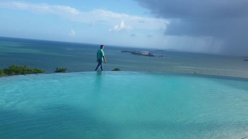 Man standing in sea against sky