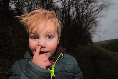 Close-up portrait of boy picking nose