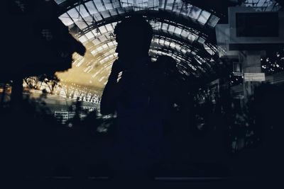 Silhouette people standing in illuminated city at night
