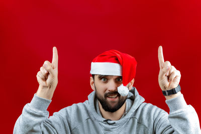 Portrait of young man wearing mask against red background