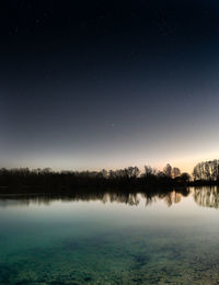 Scenic view of lake against sky at night