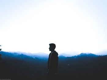 Silhouette man looking at mountain against sky