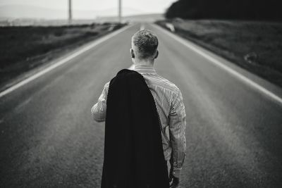 Rear view of man standing on road