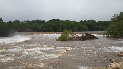 Scenic view of waterfall in river against sky