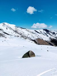 Scenic view of snowcapped mountains against blue sky