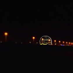 Close-up of illuminated lights against sky at night