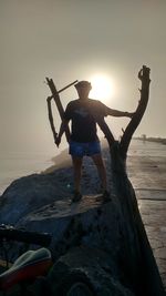 Woman standing on beach at sunset